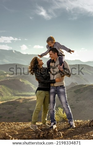 Happy family with father, mother and son walks in mountains together
