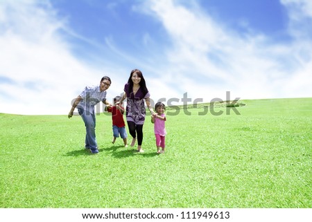 Happy family: Father, Mother, and their children. Shot outdoor in summer day