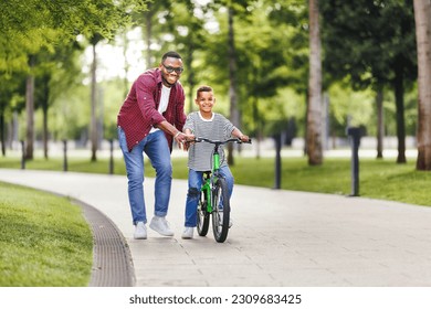 Happy family  father teaches boy son  to ride bike in  park   in nature
 - Powered by Shutterstock