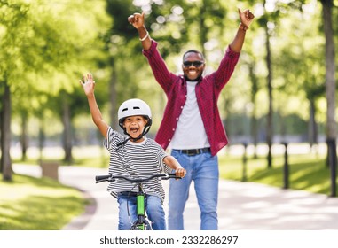 Happy family  father teaches boy son  to ride bike in  park   in nature - Shutterstock ID 2332286297