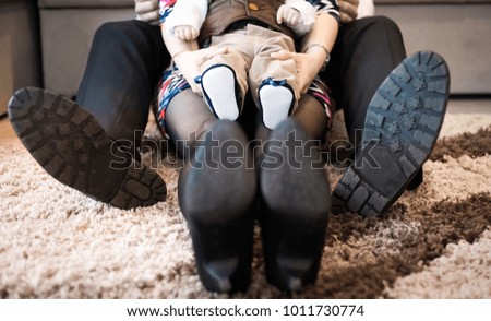 happy family feet - mother, father and baby baby sitting on carpet at home