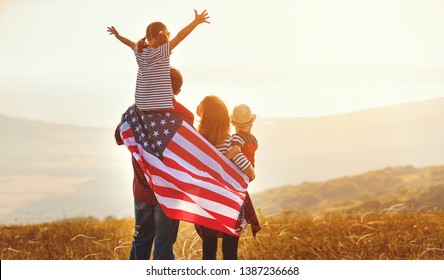 happy family with the flag of america USA at sunset outdoors
 - Powered by Shutterstock