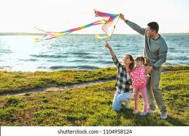 Happy Family Flying Kite Near River