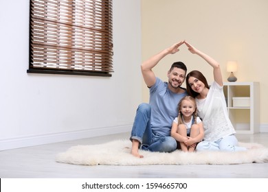 Happy Family Forming House Roof With Their Hands At Home. Insurance Concept