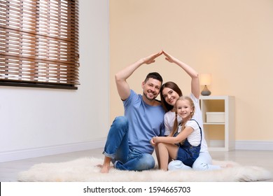 Happy Family Forming House Roof With Their Hands At Home. Insurance Concept