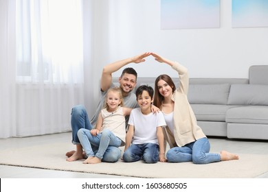 Happy Family Forming House Roof With Their Hands At Home. Insurance Concept