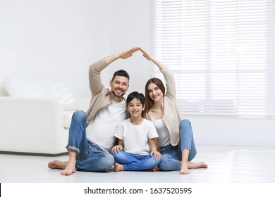 Happy Family Forming House Roof With Their Hands At Home. Insurance Concept