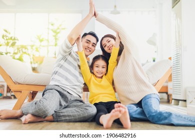 Happy Family Forming House Roof With Their Hands At Home