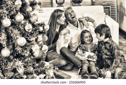 Happy Family Of Four Celebrating Chrismas Near Tree At Home. Family Concept.