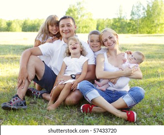 Happy Family With Four Children In Park