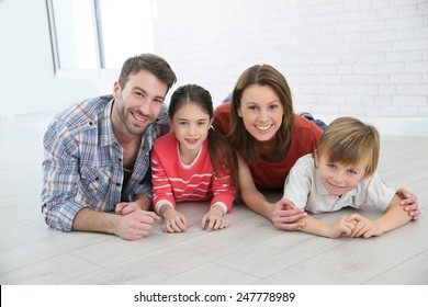 Happy Family Of Four Laying On The Floor