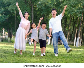 Happy family of four playing in the park high quality photo - Shutterstock ID 2006002220