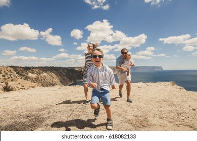 Happy Family Of Four Walking In The Mountains. Family Concept. Family Trip.