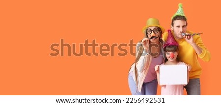 Happy family in funny disguise and with blank paper sheet on orange background. Banner for April Fools Day