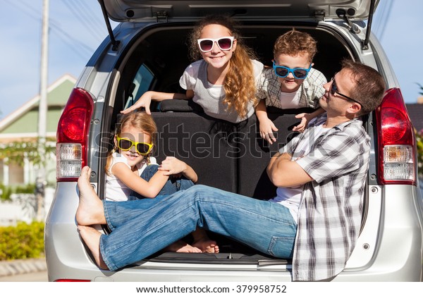 Happy family getting ready for road trip
on a sunny day.  Concept of friendly
family.