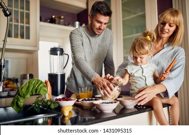 Happy Family With Girl In Kitchen Making Breakfast Together