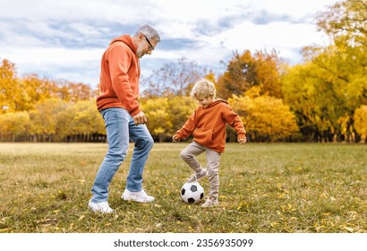 Happy family grandfather and grandson play football on lawn in the park
 - Powered by Shutterstock