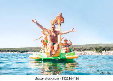 Happy family grandfather sliding down with hands up on floating Playground slide Catamaran as his multigeneration family enjoying sea trip as they have summer season vacation - Powered by Shutterstock