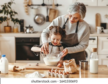 happy family grandmother and granddaughter child  cook in the kitchen, knead dough and bake cookies