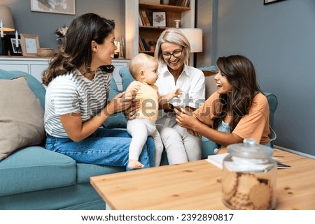 Happy family. Grandmother, mother, aunt and little baby having fun at home. Relatives visiting new born child.