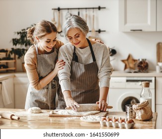 happy family grandmother  old mother mother-in-law and daughter-in-law daughter cook in kitchen, knead dough and bake cookies - Shutterstock ID 1641550699