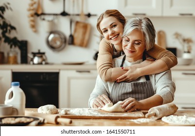 happy family grandmother  old mother mother-in-law and daughter-in-law daughter cook in kitchen, knead dough and bake cookies