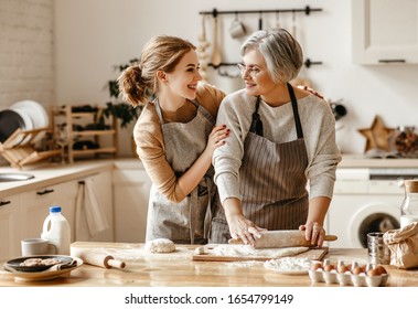 happy family grandmother  old mother mother-in-law and daughter-in-law daughter cook in kitchen, knead dough and bake cookies - Shutterstock ID 1654799149