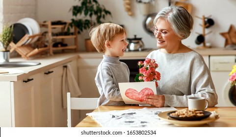 happy family grandson child congratulates grandmother on holiday and gives a card