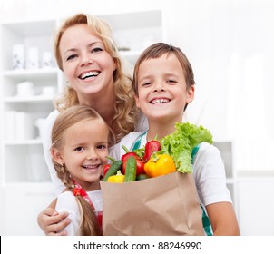 Happy Family With The Grocery Bag Full Of Fresh Vegetables - Healthy Life Concept