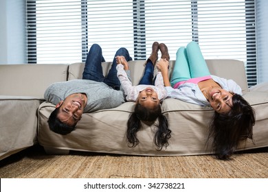 Happy Family Hanging Upside Down In Living Room