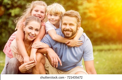 Happy Family In Harmony With Two Children Playing And Laughing