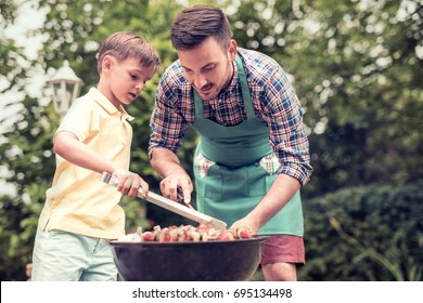 Happy Family Having Barbecue On Sunny Day.