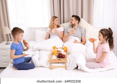 Happy family having breakfast in bed - Powered by Shutterstock