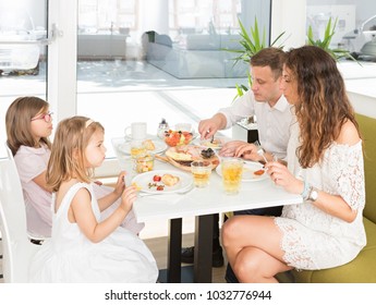 Happy Family Having Breakfast In Hotel Restaurant