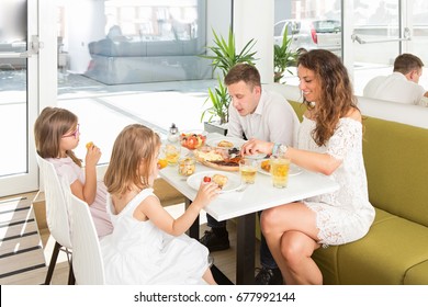 Happy Family Having Breakfast In Hotel Restaurant