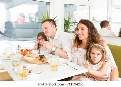 Happy Family Having Breakfast In Hotel Restaurant