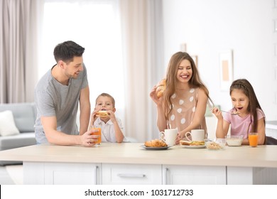 Happy Family Having Breakfast In Kitchen