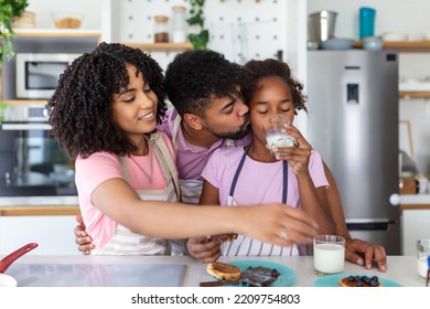 Happy Family Having Breakfast In Kitchen. Dad And Daughter With Mom Making Pancakes