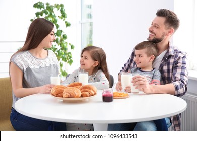 Happy Family Having Breakfast With Milk At Table