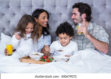 Happy family having breakfast on bed at home - Powered by Shutterstock