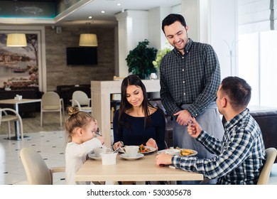 Happy Family Having Breakfast At A Restaurant