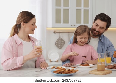 Happy family having breakfast at table in kitchen - Powered by Shutterstock