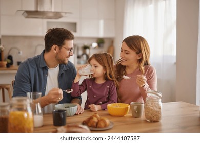 Happy family having breakfast at table in kitchen - Powered by Shutterstock