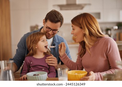 Happy family having breakfast at table in kitchen - Powered by Shutterstock