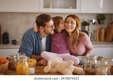 Happy family having breakfast at table in kitchen  - Powered by Shutterstock