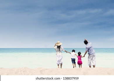 Happy Family Having Fun At Beach During Summer Day