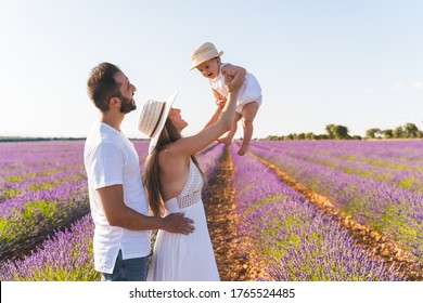 Happy Family Having Fun In A Field Of Flowers. Spanish Family Into A Field Of Lavanda Flowers. Caucasian Family Having Fun Outdoors. Family Concept.