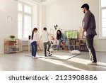 Happy family having fun at home. Kids playing soccer with mom and dad. Brother and sister playing football together with parents in big living room with large television set in new modern apartment