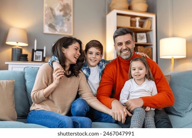 Happy family having fun at home, parents and little children sit on sofa together, Happy family sitting on sofa laughing together. Cheerful parents playing with their kids at home. - Powered by Shutterstock