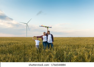 Happy family having fun with kite on the field. Beautiful family with flying colorful kite over clear sky. Free, freedom concept. - Shutterstock ID 1766544884